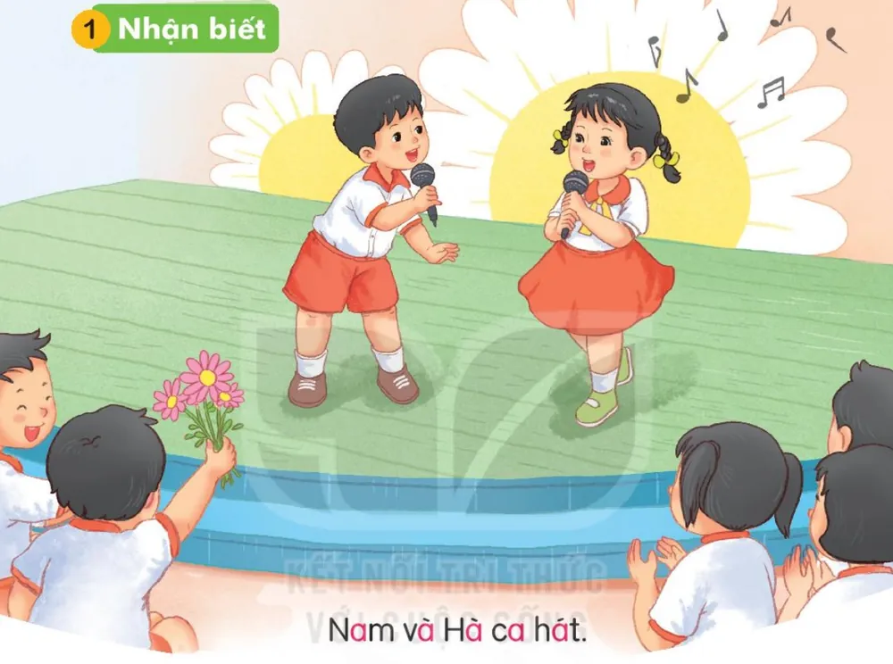 Nam và Hà cầm micro hát trên sân khấu, các bạn vỗ tay.