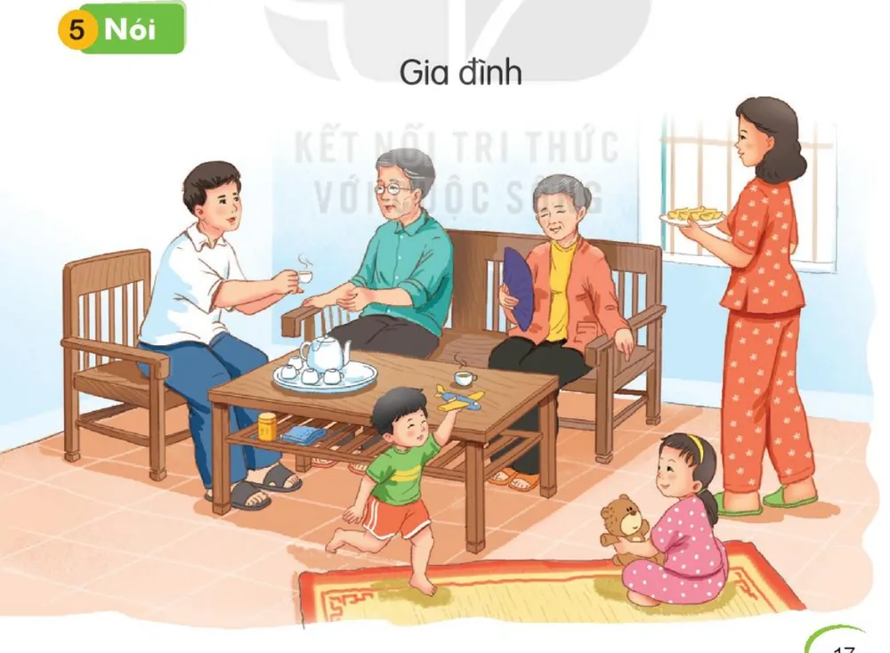 cả nhà ngồi uống nước, trò chuyện trong phòng khách.