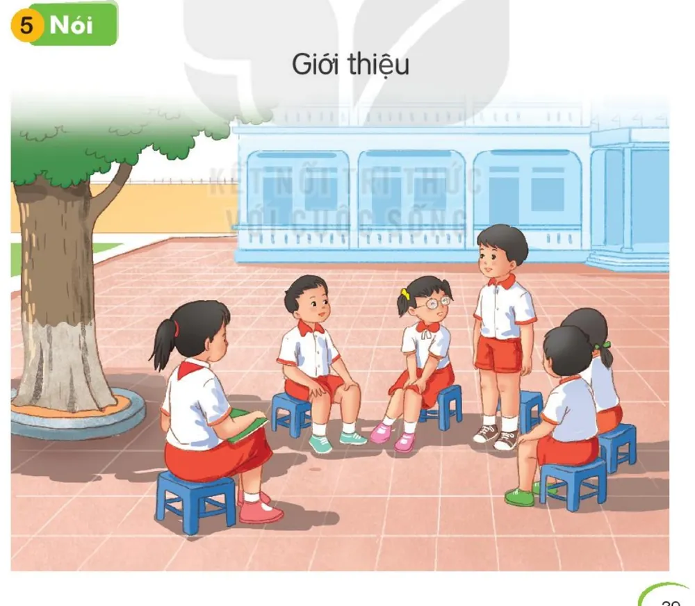 các bạn ngồi thành vòng trên sân trường, một bạn đứng lên giới thiệu.
