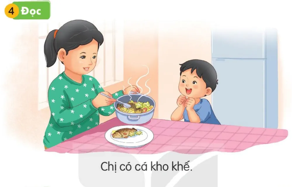 chị múc cá kho khế ra đĩa, em reo thích thú.