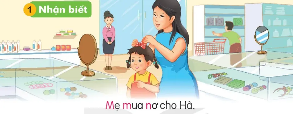 Mẹ cài nơ cho Hà ở cửa hàng. Câu dưới tranh: "Mẹ mua nơ cho Hà."