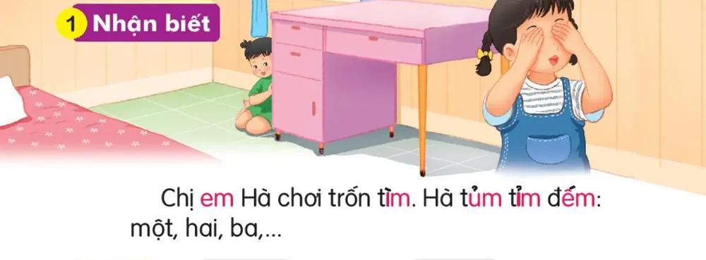 Hà che mắt đếm, em nấp sau bàn. Câu dưới tranh: "Chị em Hà chơi trốn tìm. Hà tủm tỉm đếm: một, hai, ba,..."